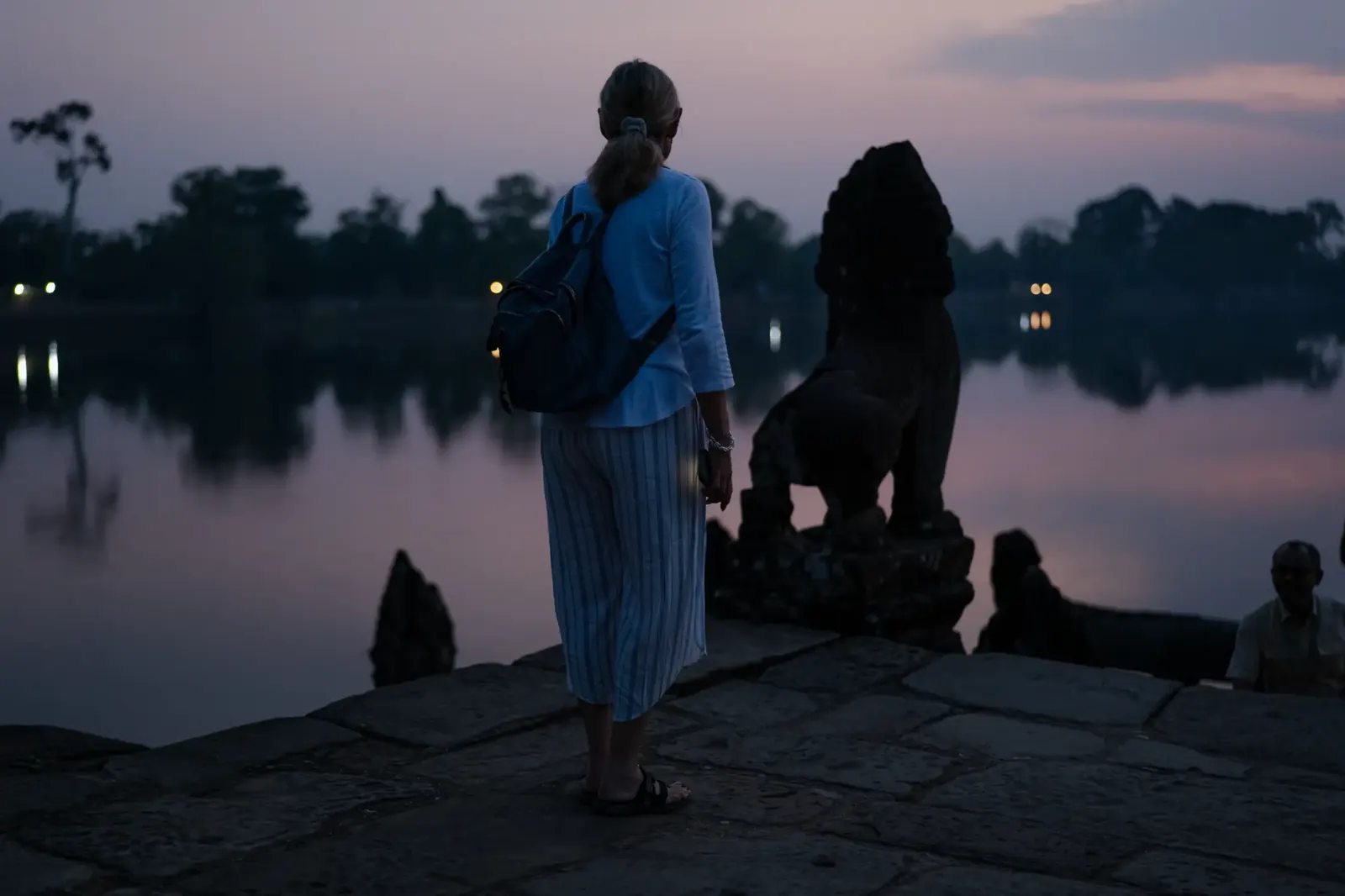 Susan at Srah Srang lake at twilight with lion statue - Cambodia
