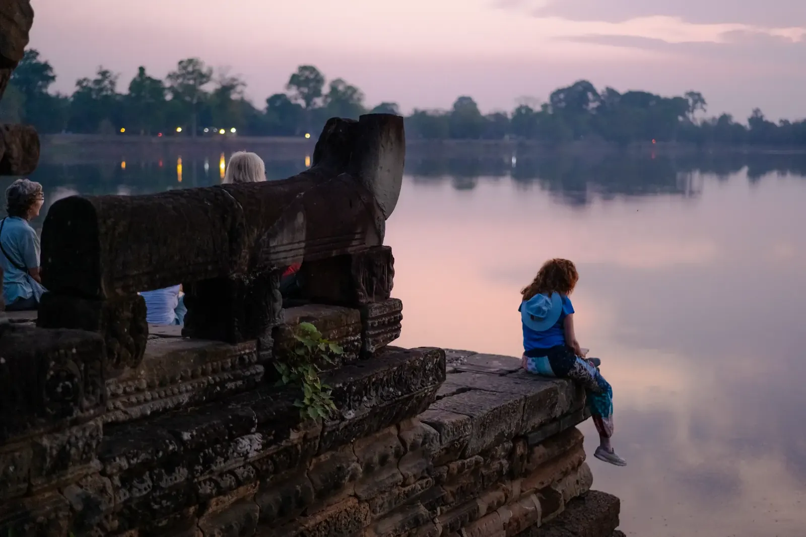 Retreat participants at ancient temple by the lake at sunset - Cambodia