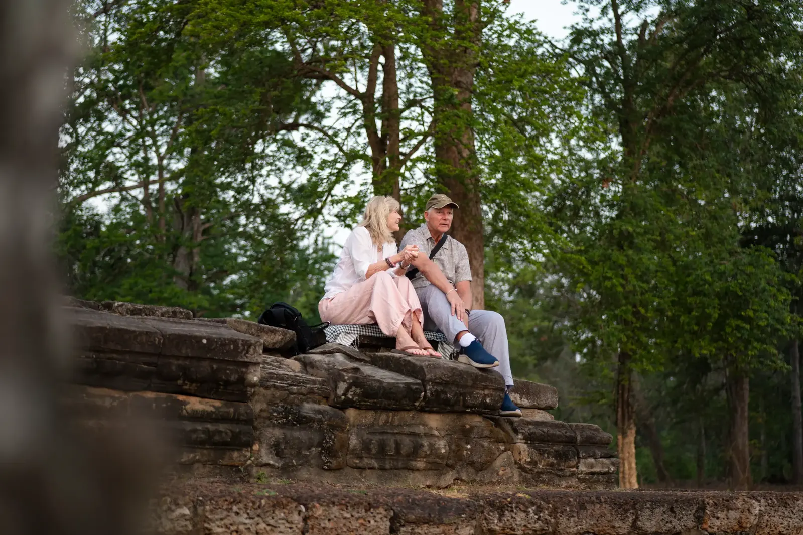 Susan and companion relaxing on ancient temple ruins - Cambodia