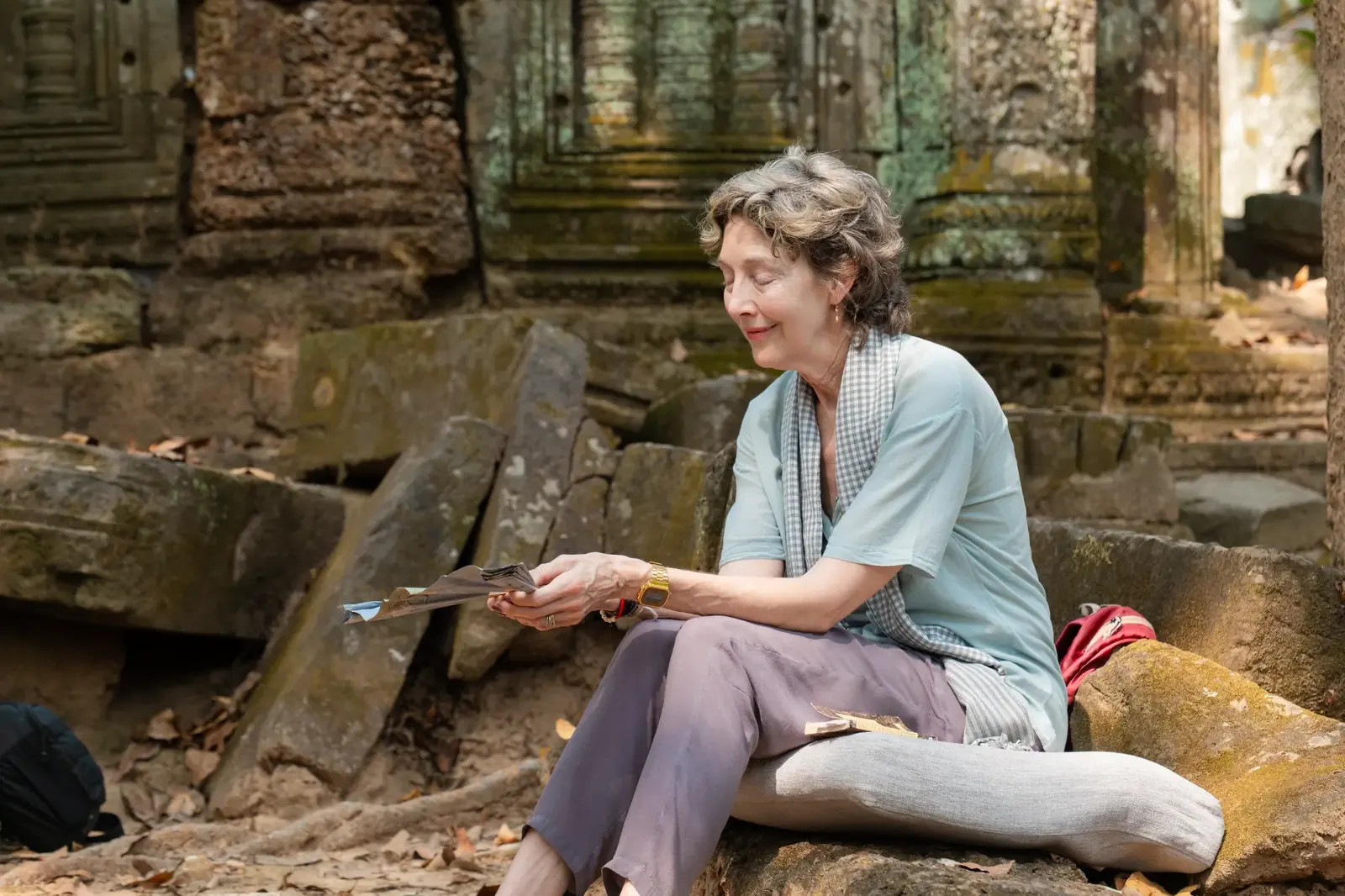 Susan sitting in meditation at temple ruins - Cambodia