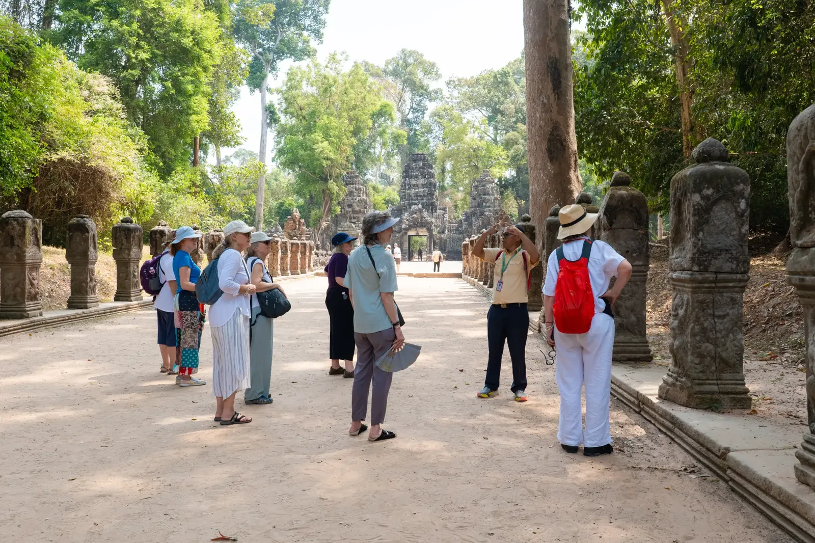 Retreat group photo with monks on temple steps - Cambodia
